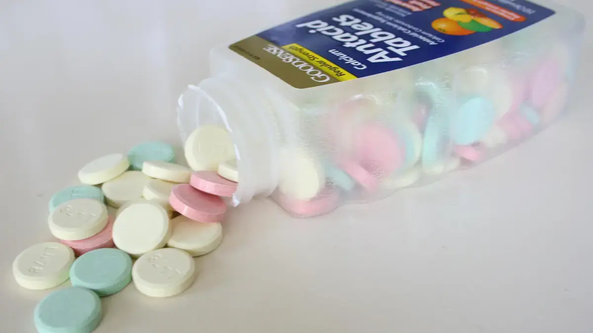 A bottle of multicoloured antacid tablets lying on its side