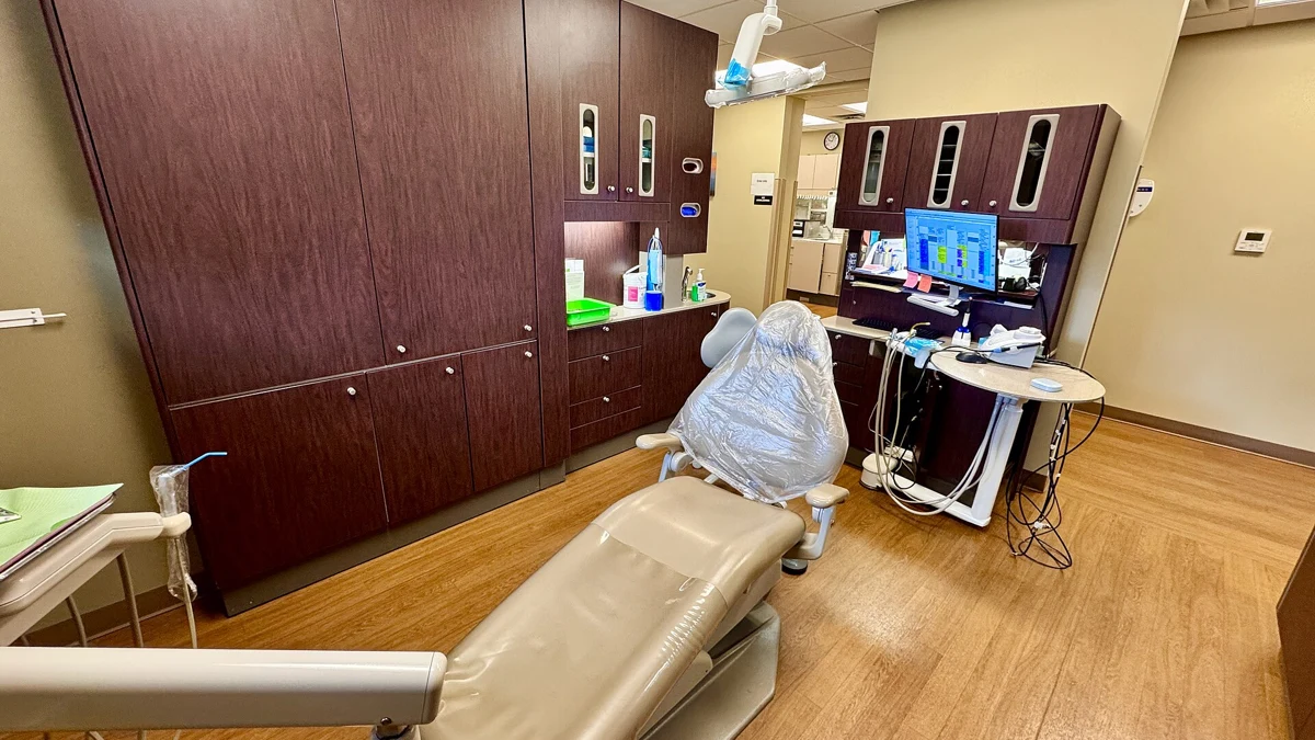 An empty dental chair with an examination light in a clinic