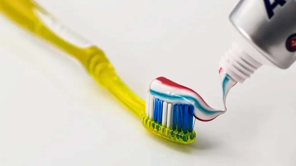 A toothbrush beside a tube of toothpaste