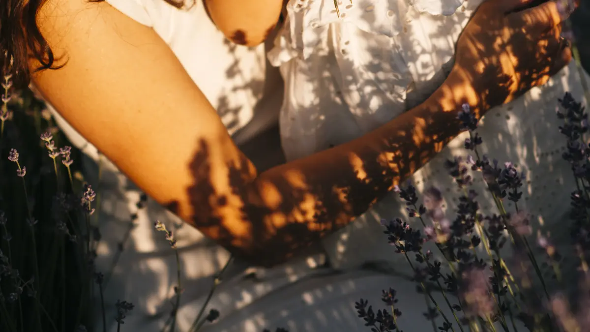 A woman holding a child in a lavender field at sunset