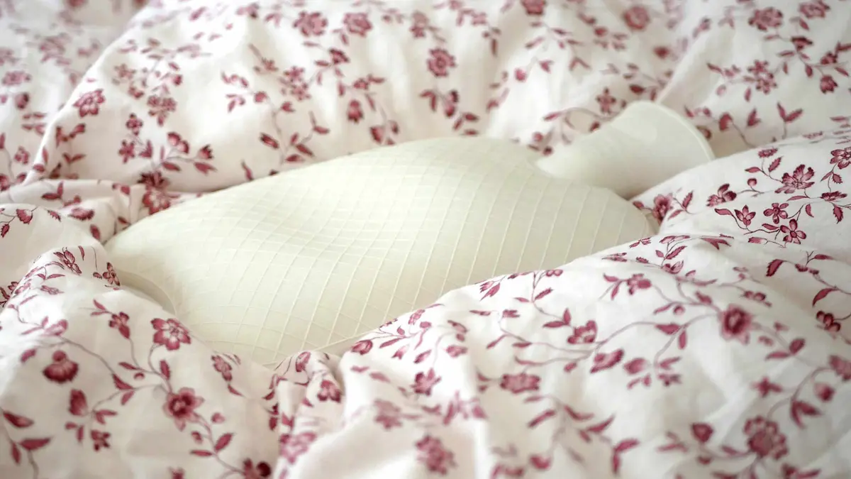 A hot-water bottle resting on folded bedding