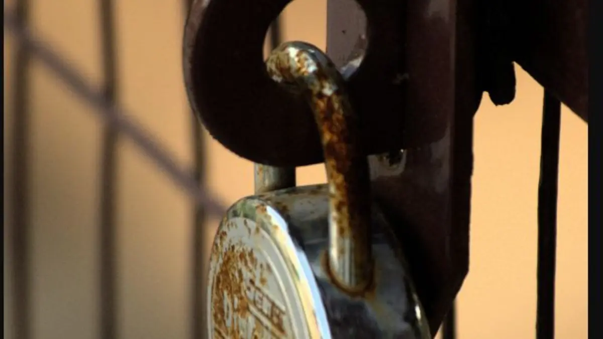 Close view of a weathered metal padlock