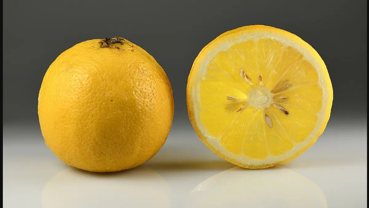 A whole bergamot orange and a cut half showing the pale flesh