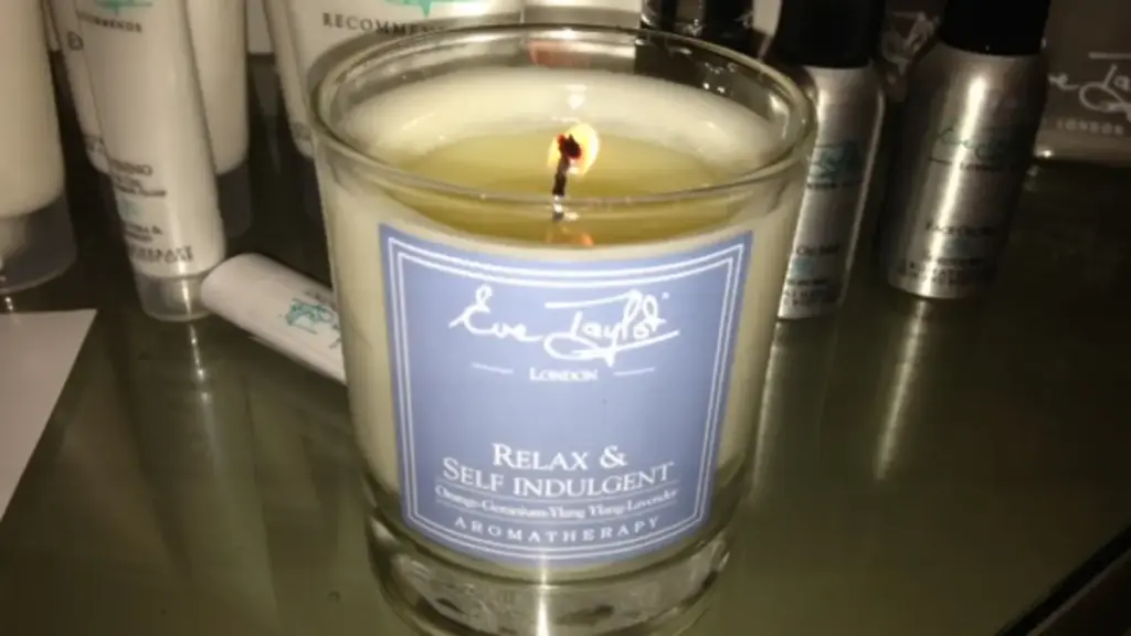 A lit candle in a glass jar on a table