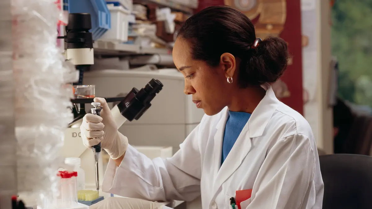 A laboratory researcher working carefully with pipettes