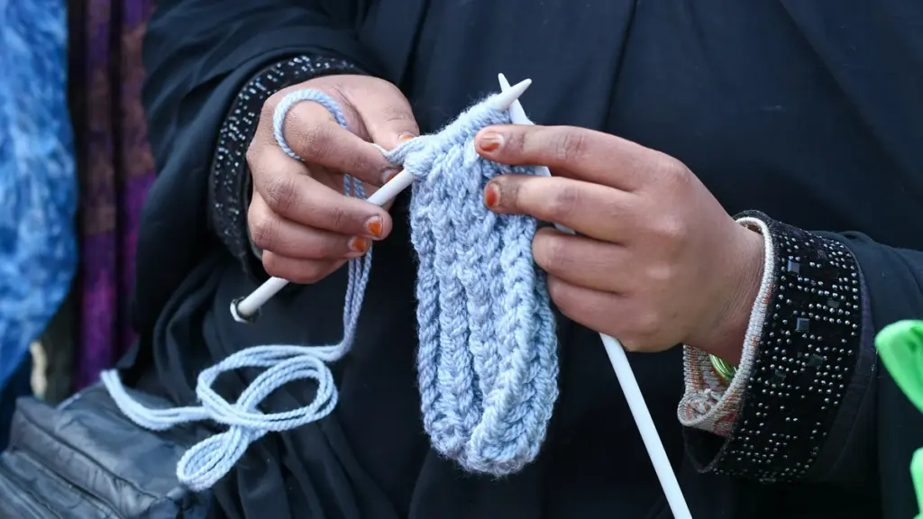 Hands knitting with pale blue yarn