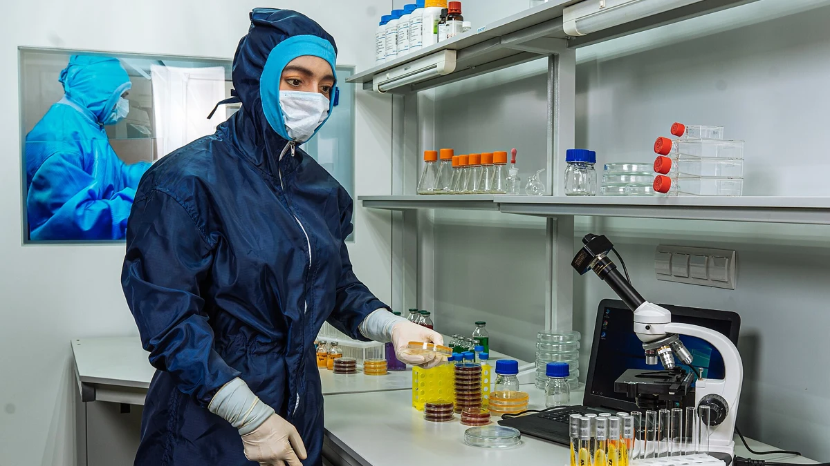 Laboratory staff working beside a microscope and sample containers
