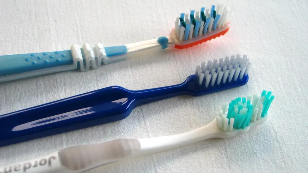 Three toothbrushes with differently coloured bristles