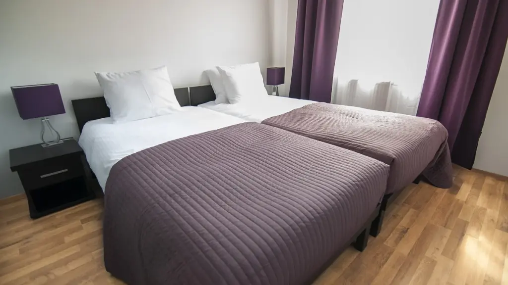 Beds with pillows and covers in a quiet bedroom