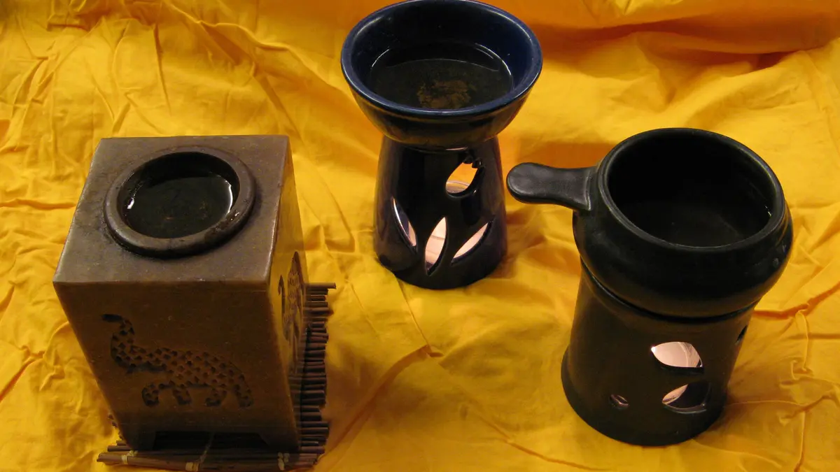 Three ceramic aroma lamps with bowls above openings for tealights